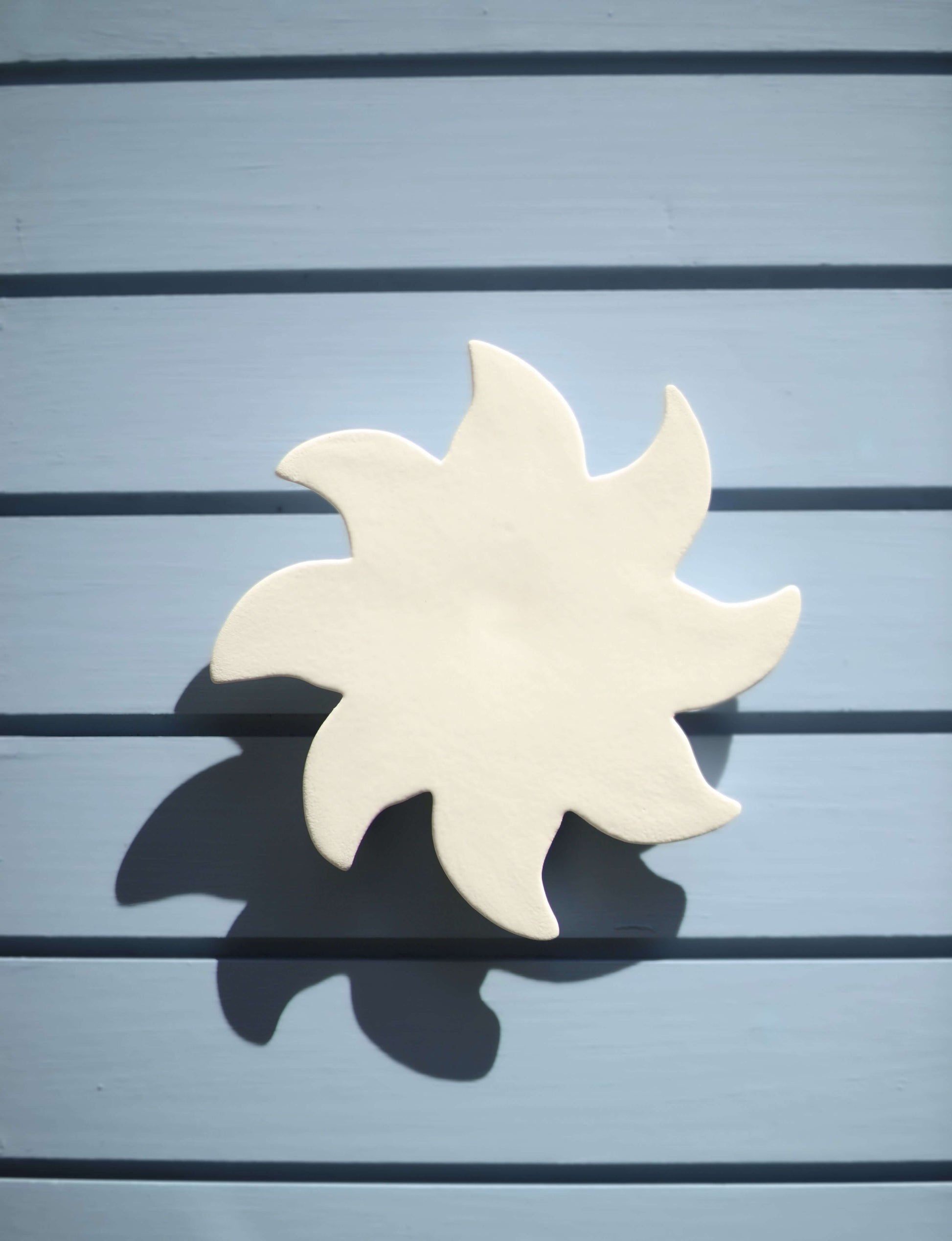 soleil à accrocher au mur en céramique couleur blanche minéral