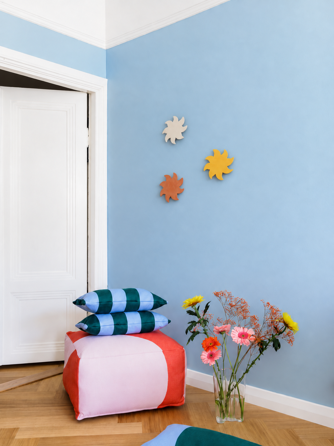 Soleils muraux en céramique dans une chambre d’enfant au mur bleu pastel